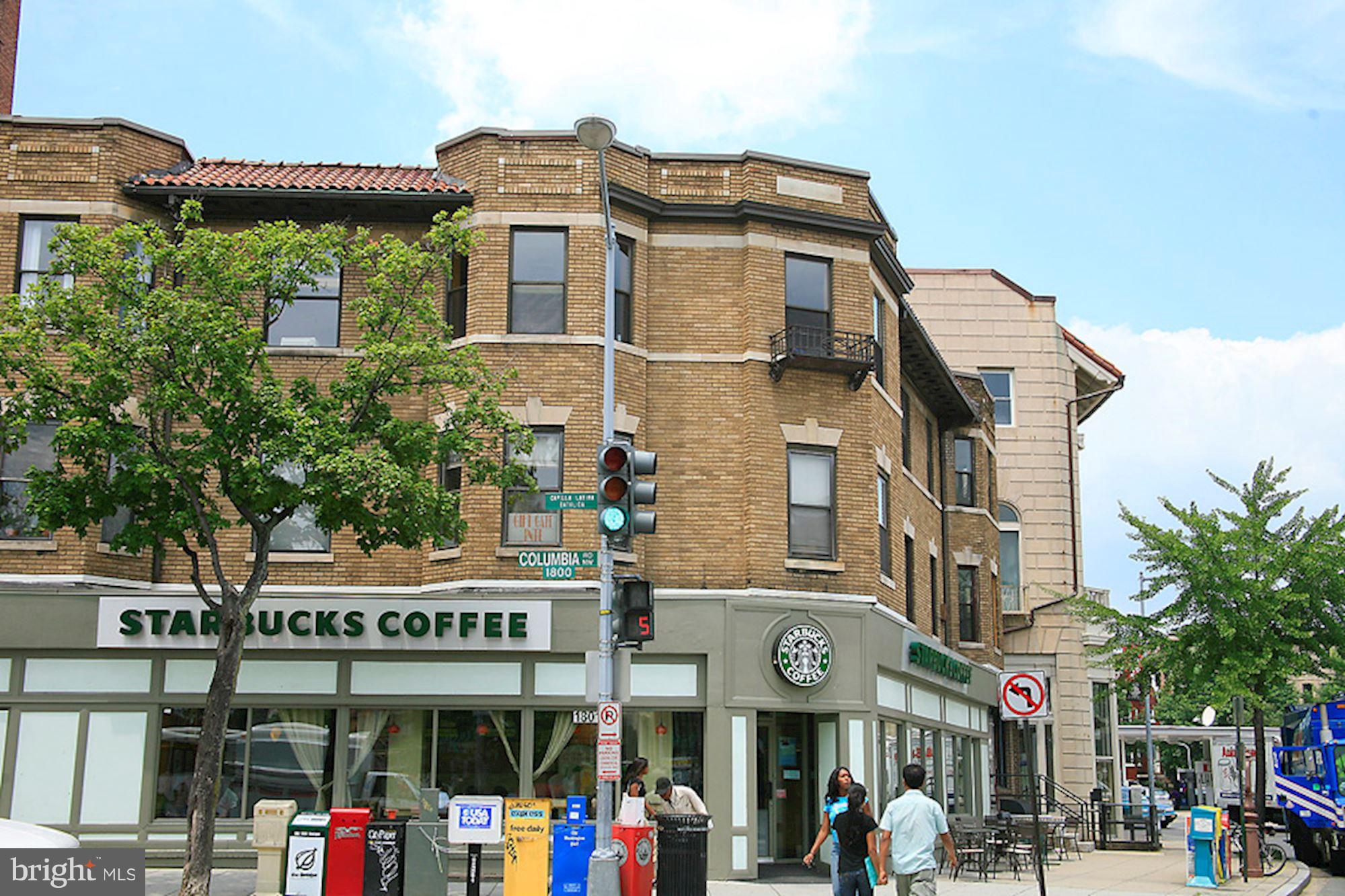 1851 Columbia Road Northwest, Unit 305 Washington, DC 20009 - Photo 24 of 28 a view of a building with a street sign and a couple of people