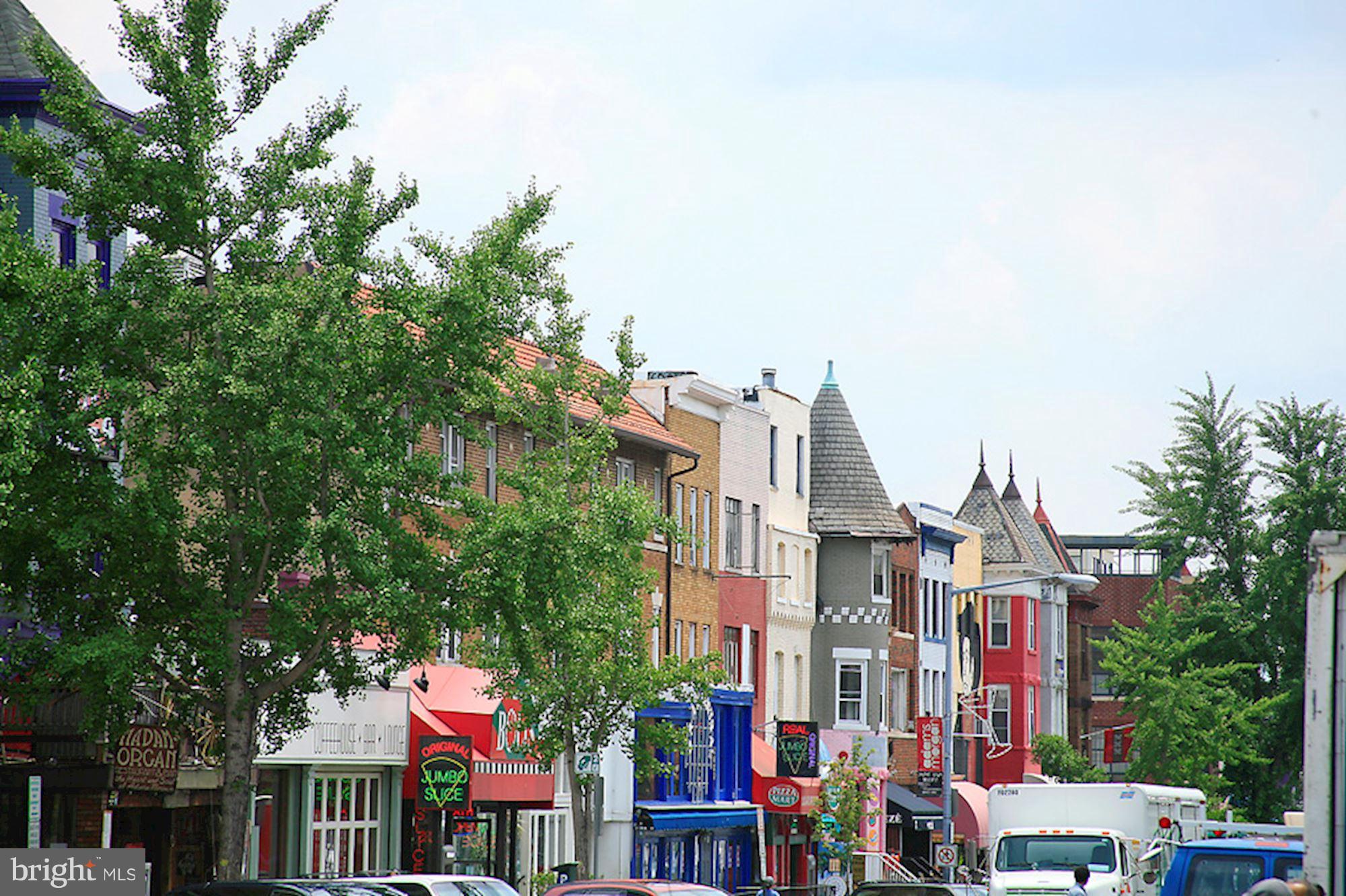 1851 Columbia Road Northwest, Unit 305 Washington, DC 20009 - Photo 25 of 28 a front view of multi story residential apartment building with yard and retail shops