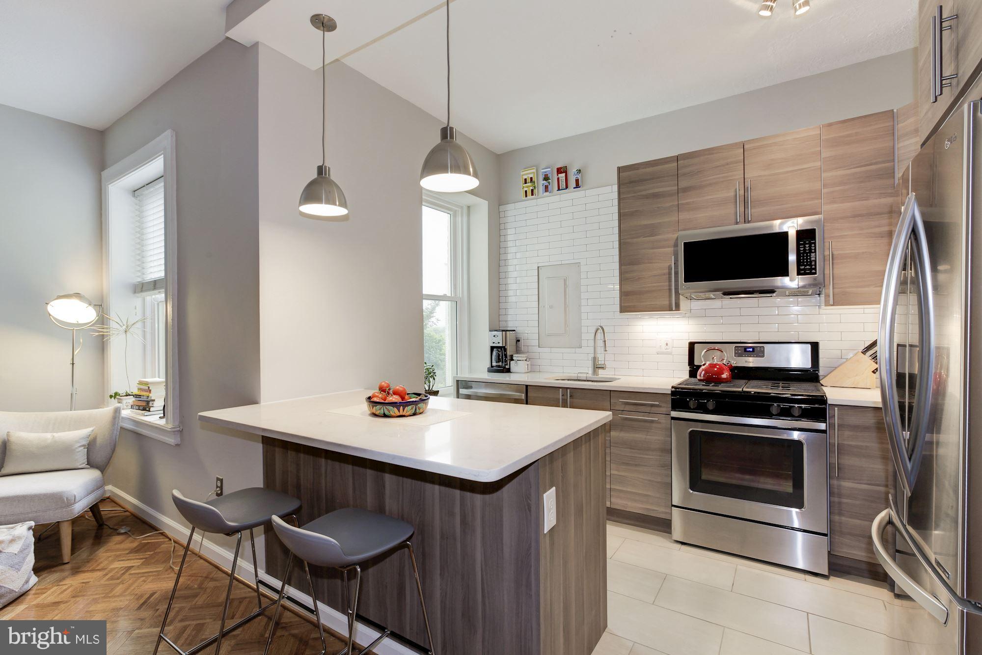 1851 Columbia Road Northwest, Unit 305 Washington, DC 20009 - Photo 5 of 28 a kitchen with a stove a sink and a refrigerator