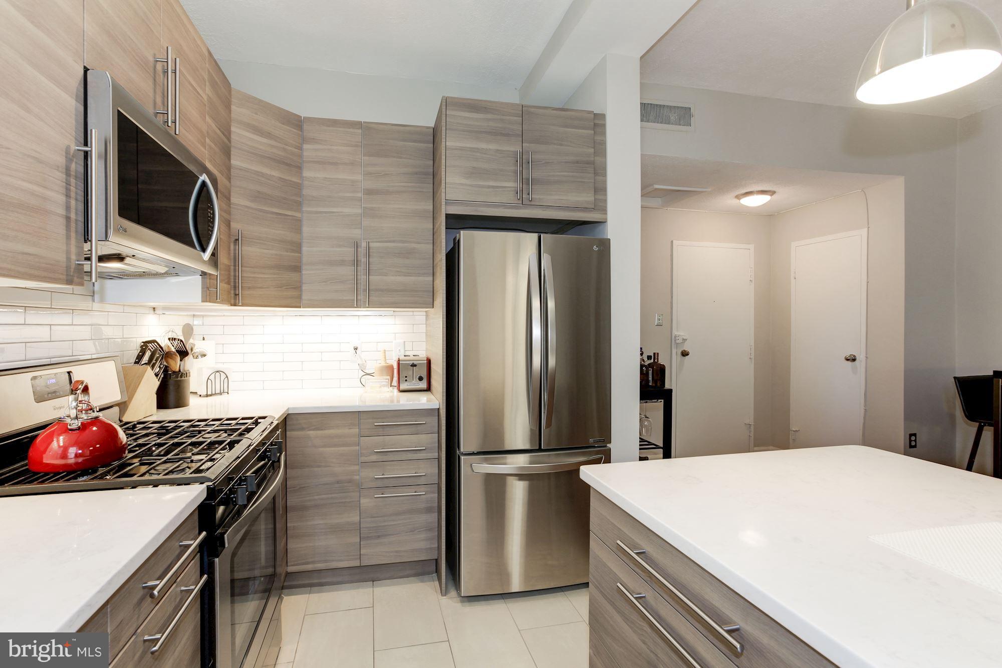 1851 Columbia Road Northwest, Unit 305 Washington, DC 20009 - Photo 6 of 28 a kitchen with stainless steel appliances a stove microwave and refrigerator