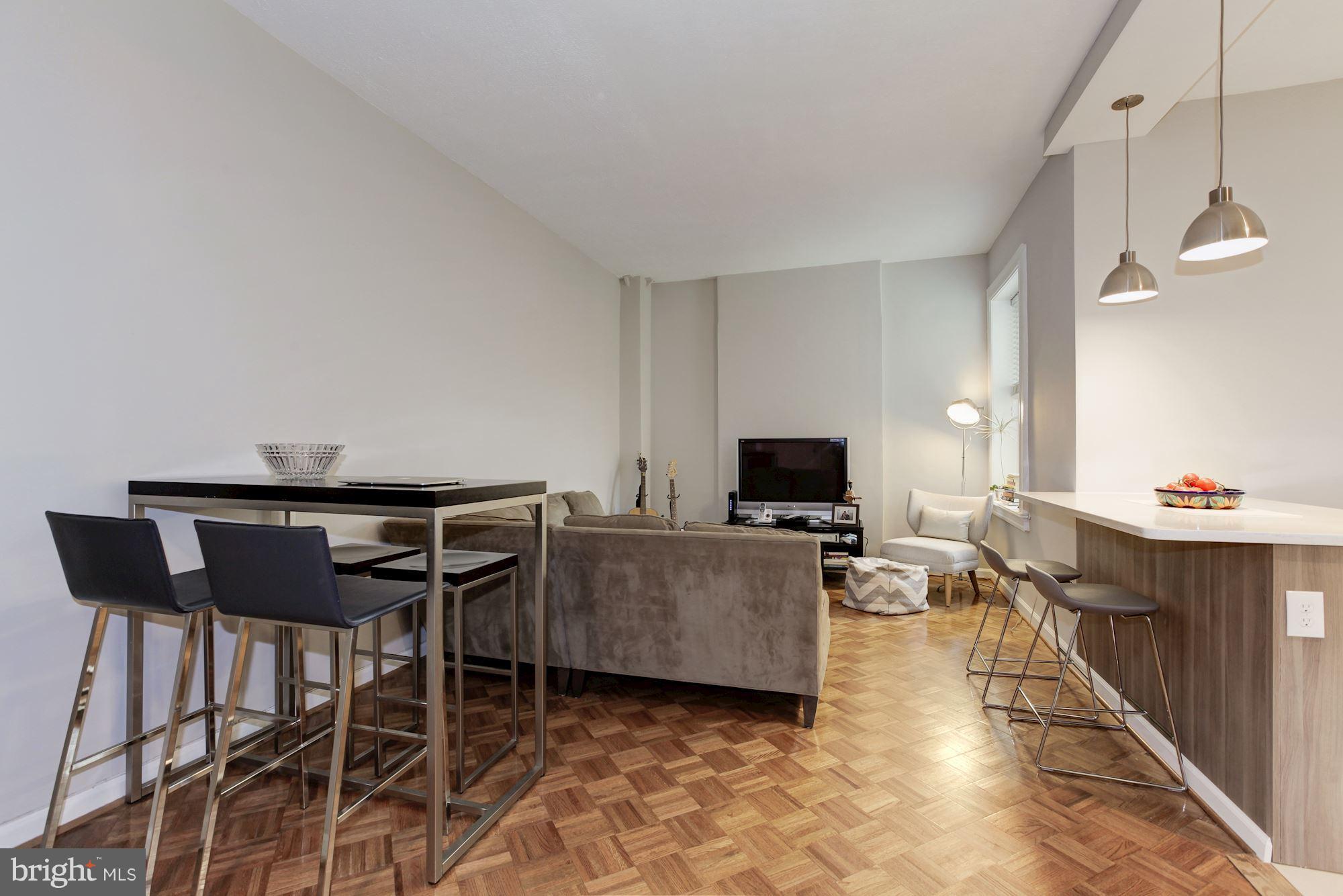 1851 Columbia Road Northwest, Unit 305 Washington, DC 20009 - Photo 7 of 28 a living room with furniture a flat screen tv and kitchen view