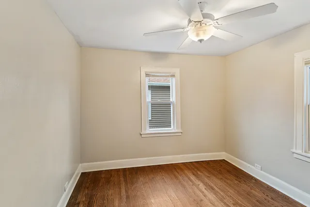 an empty room with a window and a fan