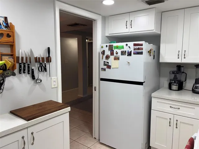 a kitchen with granite countertop white cabinets and white appliances
