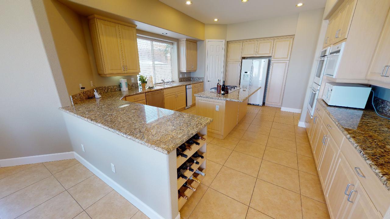 8 Picasso Court Rancho Mirage, CA 92270 - Photo 21 of 26 a view of a kitchen with kitchen island granite countertop a sink and a refrigerator