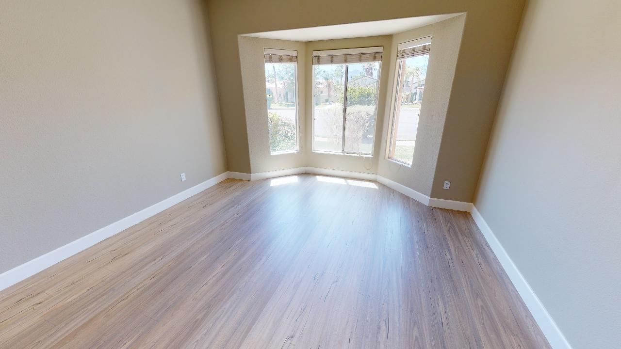 8 Picasso Court Rancho Mirage, CA 92270 - Photo 9 of 26 an empty room with wooden floor and windows