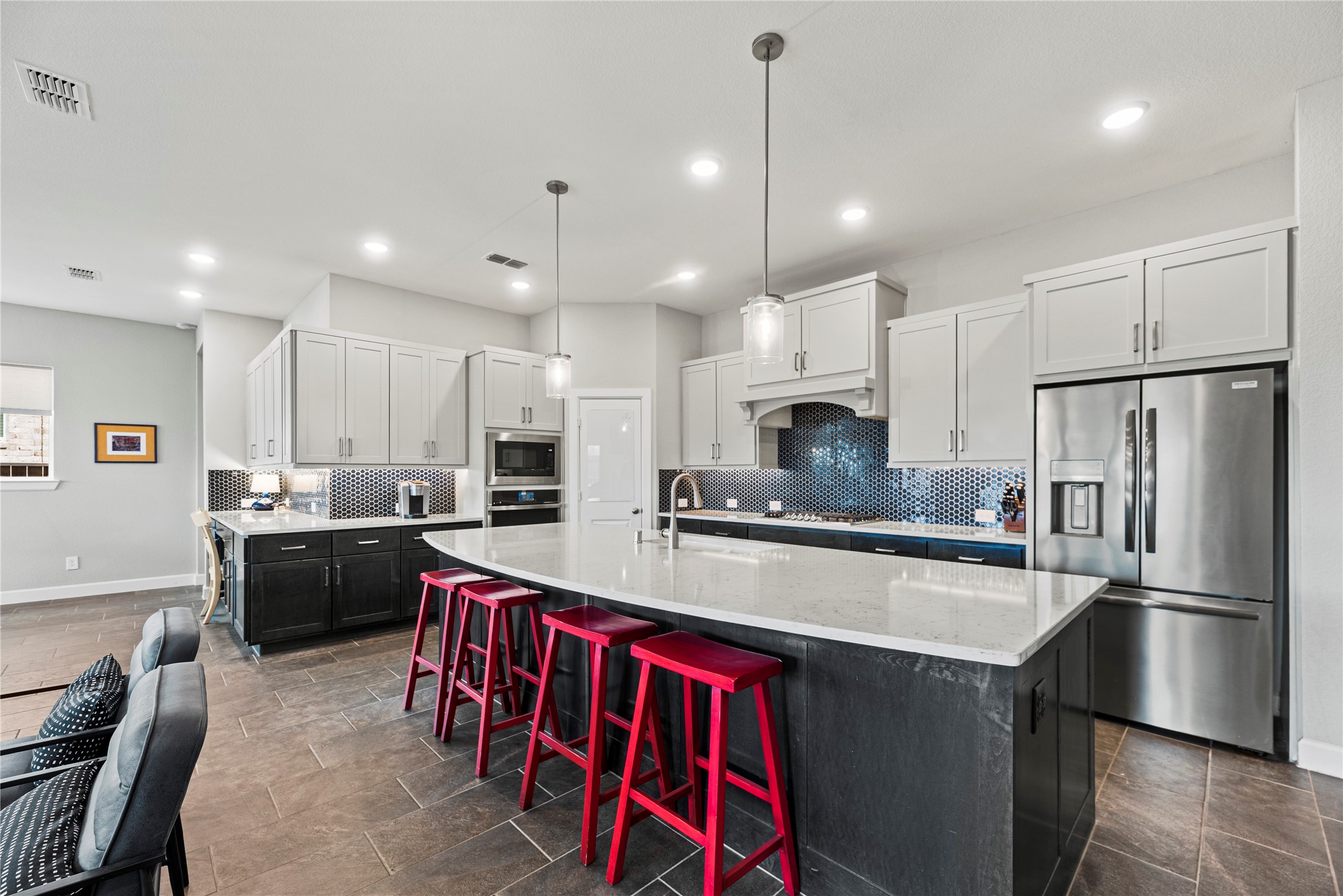 3127 Swift Way Katy, TX 77493 - Photo 11 of 25 Gorgeous island kitchen features white cabinetry, tile backsplash, under cabinet lighting and stainless steel appliances.