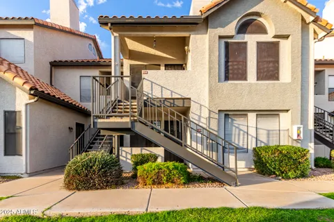 a front view of a house with a yard and potted plants