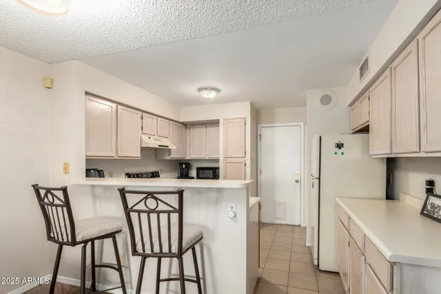 a kitchen with stainless steel appliances a white cabinets wooden floor and a sink