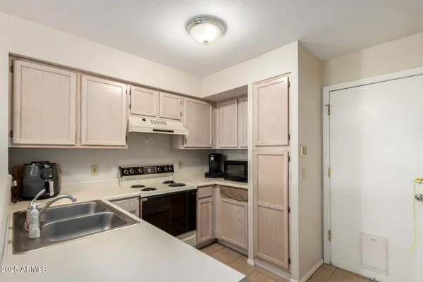 a kitchen with a refrigerator sink and cabinets