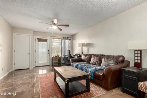 a living room with furniture and a ceiling fan