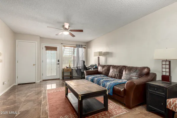 a living room with furniture and a ceiling fan