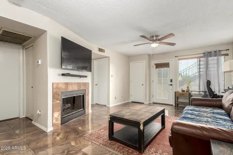 a living room with furniture a fireplace and a flat screen tv