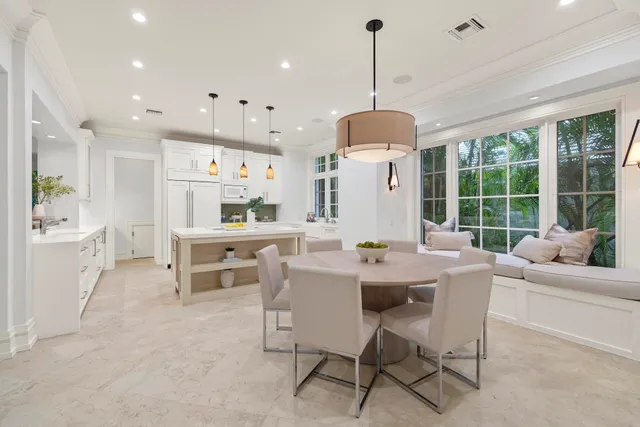 a dining room with furniture a chandelier and a large window