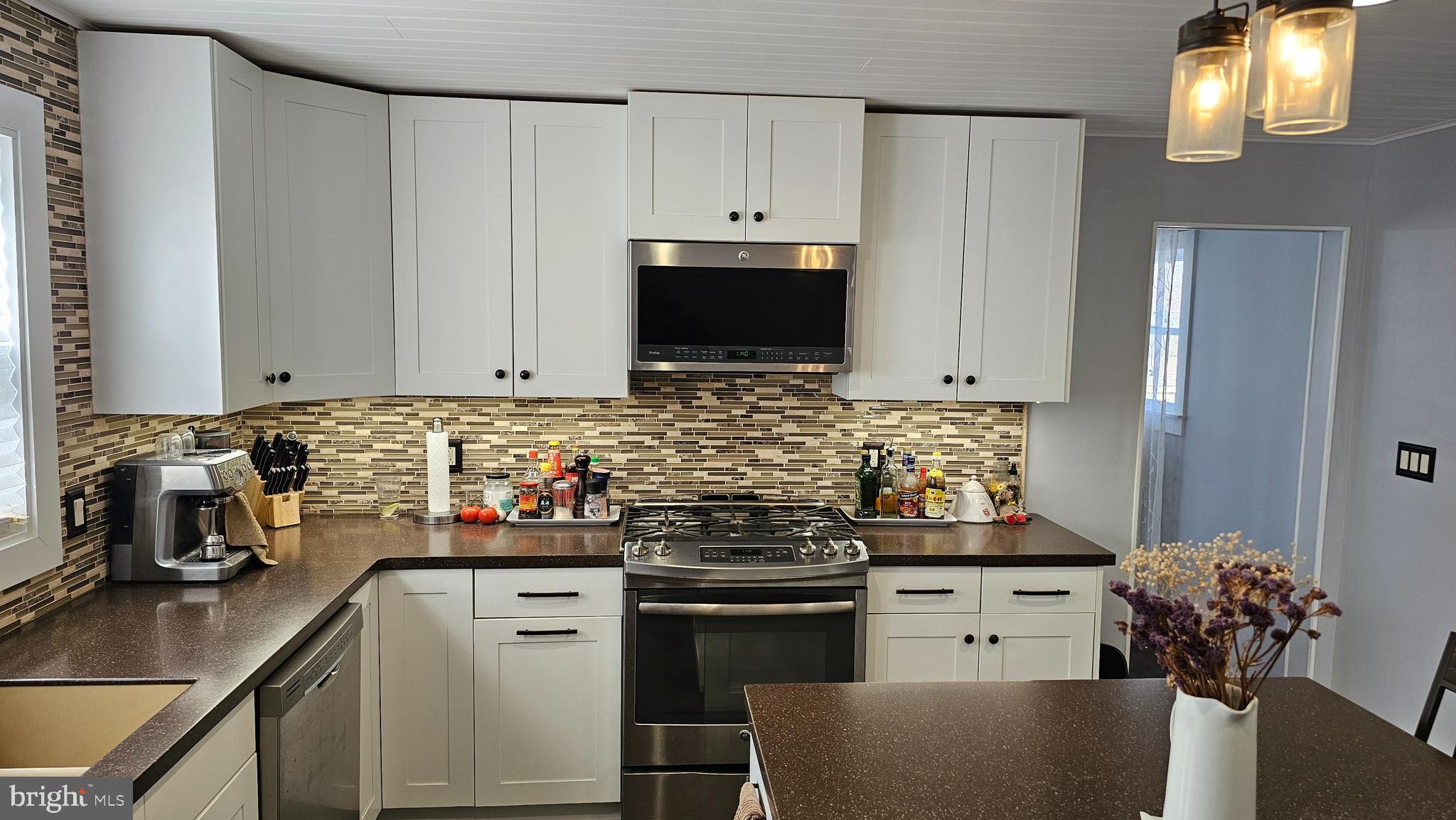 74 Ribsam Street Hamilton, NJ 08619 - Photo 12 of 35 a kitchen with stainless steel appliances white cabinets and a stove top oven