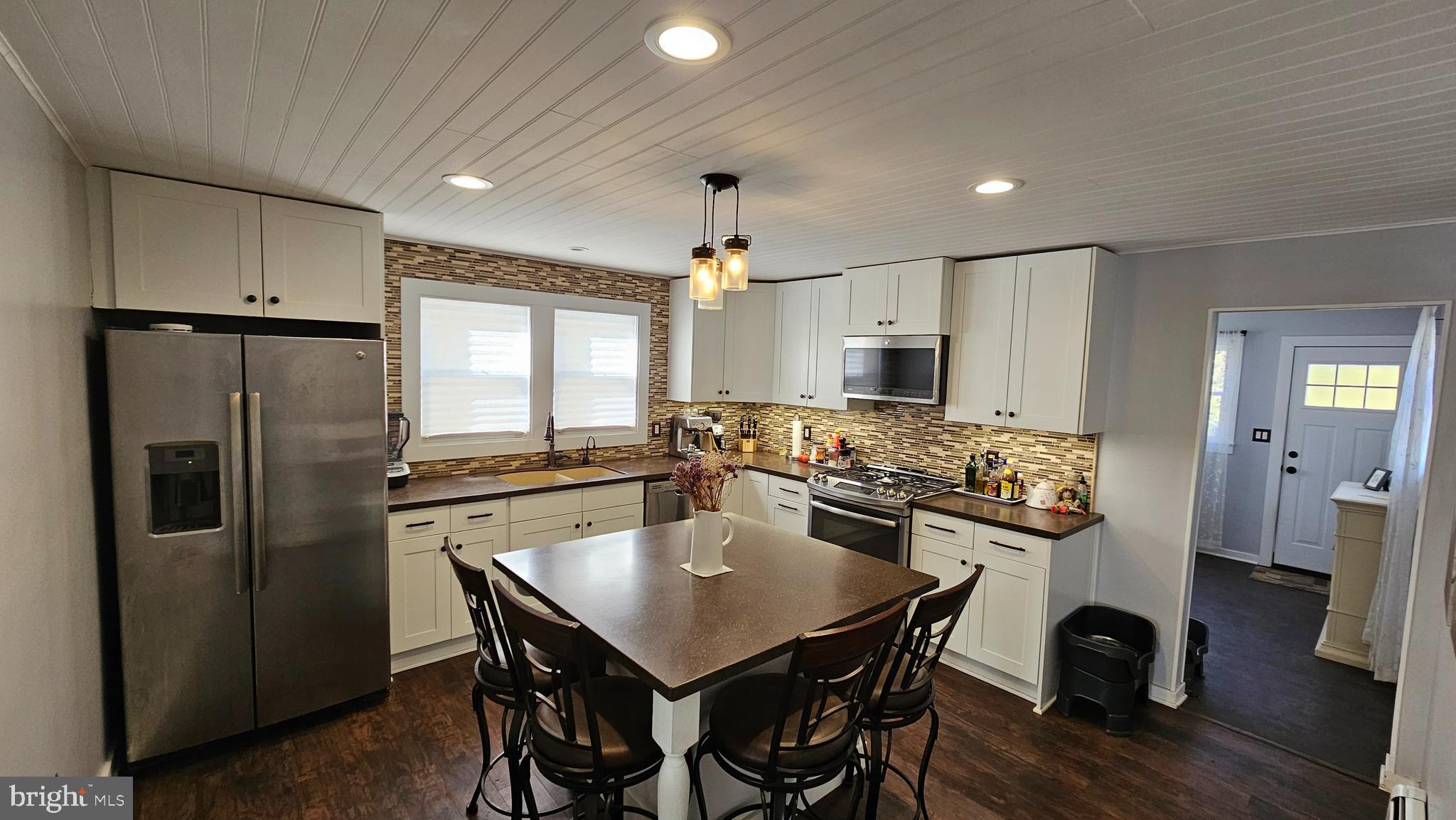 74 Ribsam Street Hamilton, NJ 08619 - Photo 14 of 35 a kitchen with refrigerator cabinets dining table and chairs
