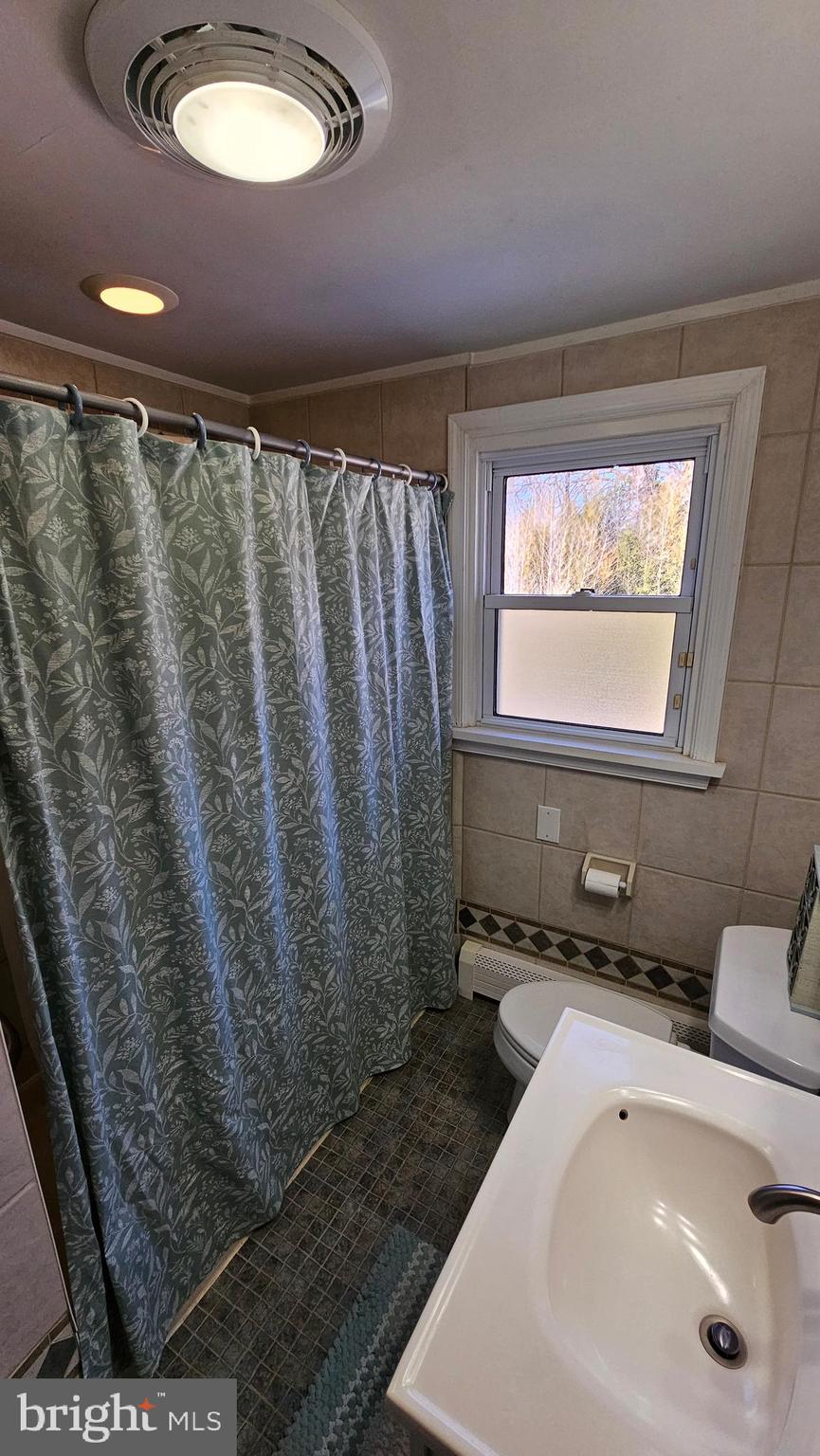 74 Ribsam Street Hamilton, NJ 08619 - Photo 26 of 35 a bathroom with a sink a mirror and a shower