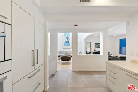 a large white kitchen with a refrigerator a stove and a sink