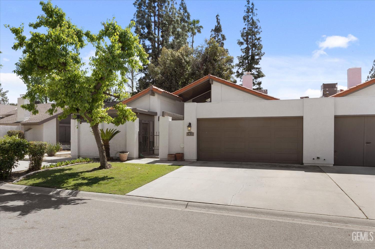 Undisclosed Address Bakersfield, CA 93309 - Photo 8 of 35 a front view of a house with a yard and garage