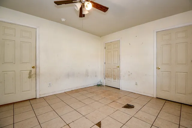 an empty room with chandelier fan