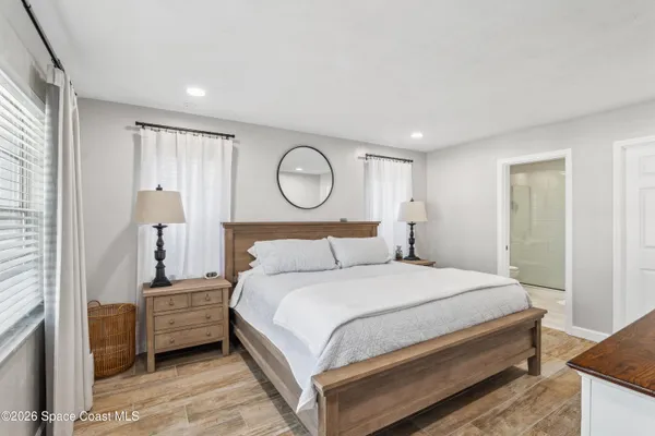 a bedroom with a bed and wooden floor