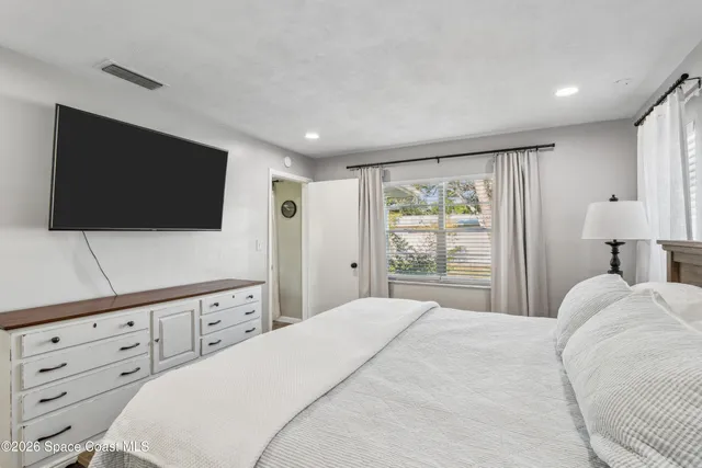 a bedroom with a bed and a flat screen tv
