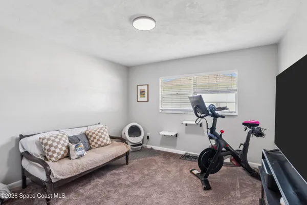 a view of a livingroom with furniture and gym equipment