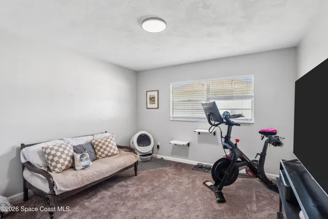a view of a livingroom with furniture and gym equipment