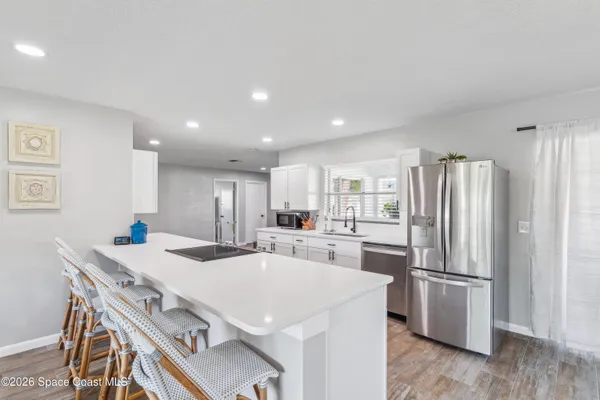a kitchen with kitchen island a sink stove and refrigerator