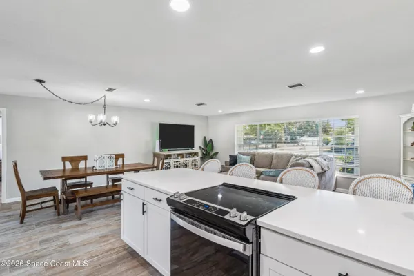 a living room with furniture a flat screen tv and a floor to ceiling window