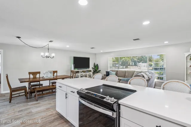 a living room with furniture a flat screen tv and a floor to ceiling window
