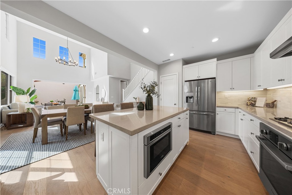105 Copeland Irvine, CA 92618 - Photo 20 of 46 a kitchen with a stove a refrigerator and a dining table