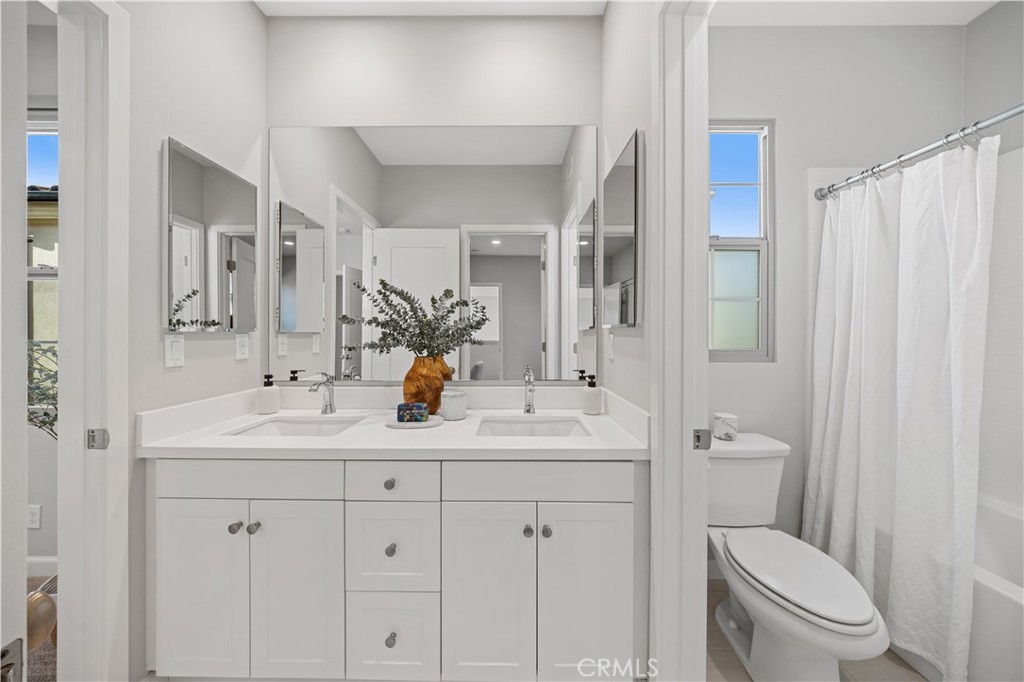 105 Copeland Irvine, CA 92618 - Photo 29 of 46 a bathroom with double sink a toilet a mirror and shower