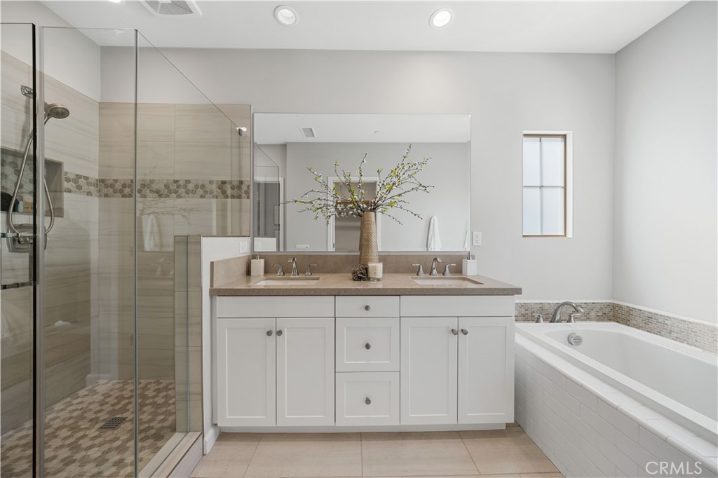 105 Copeland Irvine, CA 92618 - Photo 37 of 46 a bathroom with a granite countertop sink a mirror and a bathtub