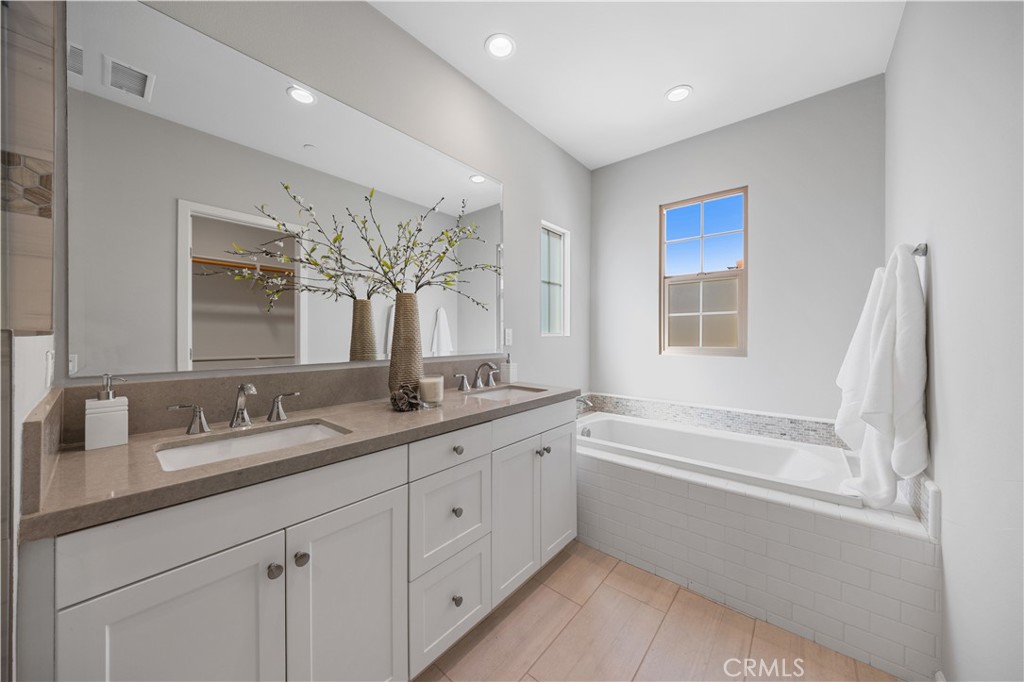 105 Copeland Irvine, CA 92618 - Photo 38 of 46 a bathroom with a granite countertop sink mirror and a bathtub