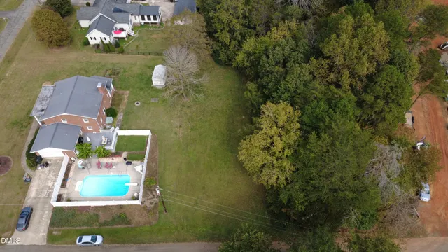 an aerial view of residential houses with outdoor space and trees