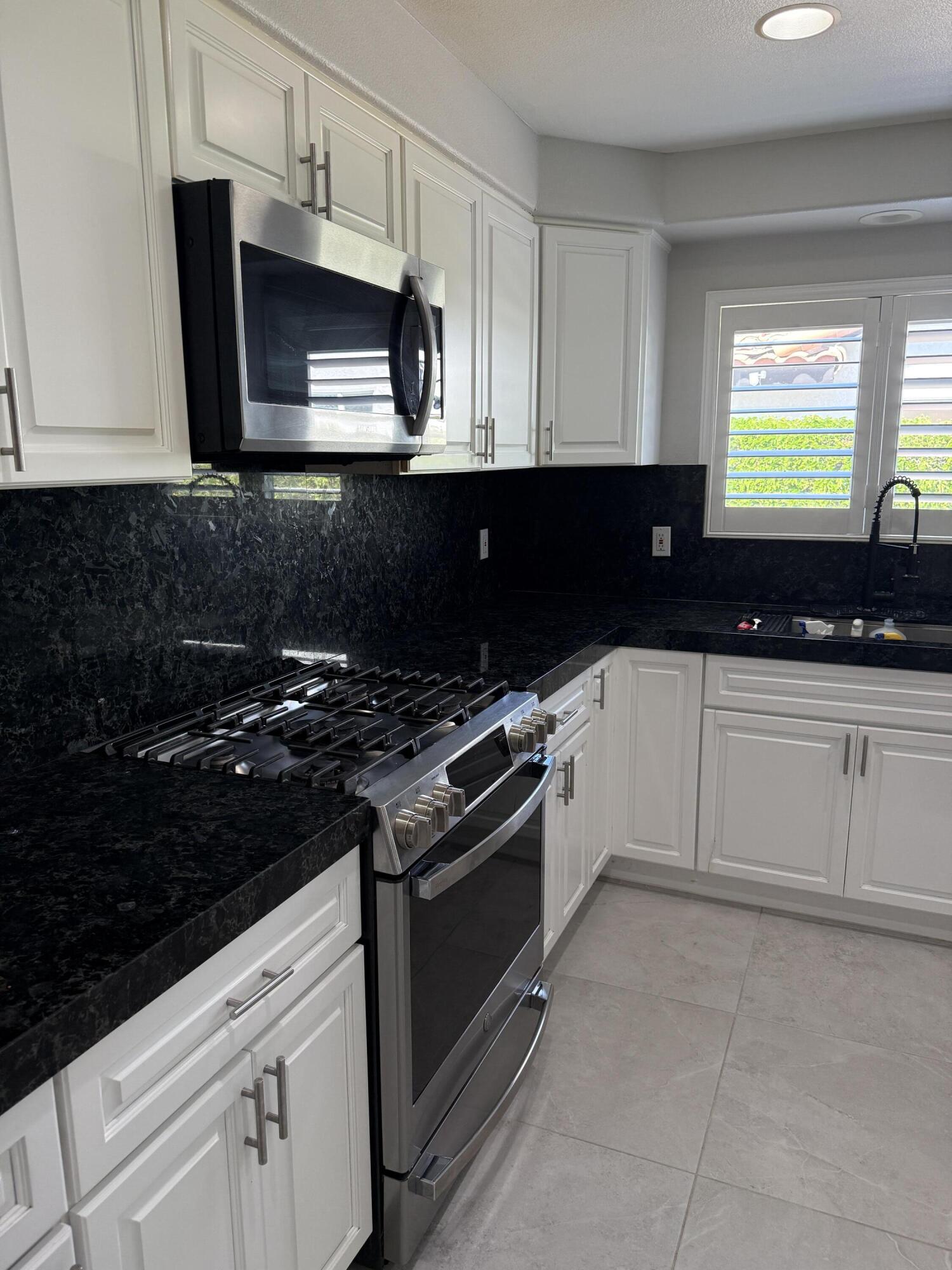 a kitchen with a sink and steel appliances