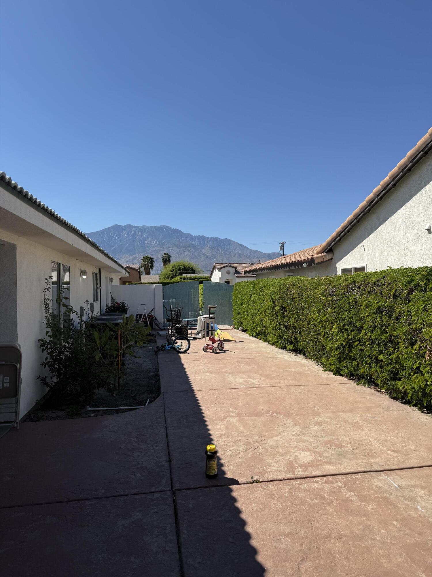 32790 Aurora Vista Road Cathedral City, CA 92234 - Photo 17 of 18 a view of a patio with couches and table and chairs with wooden fence