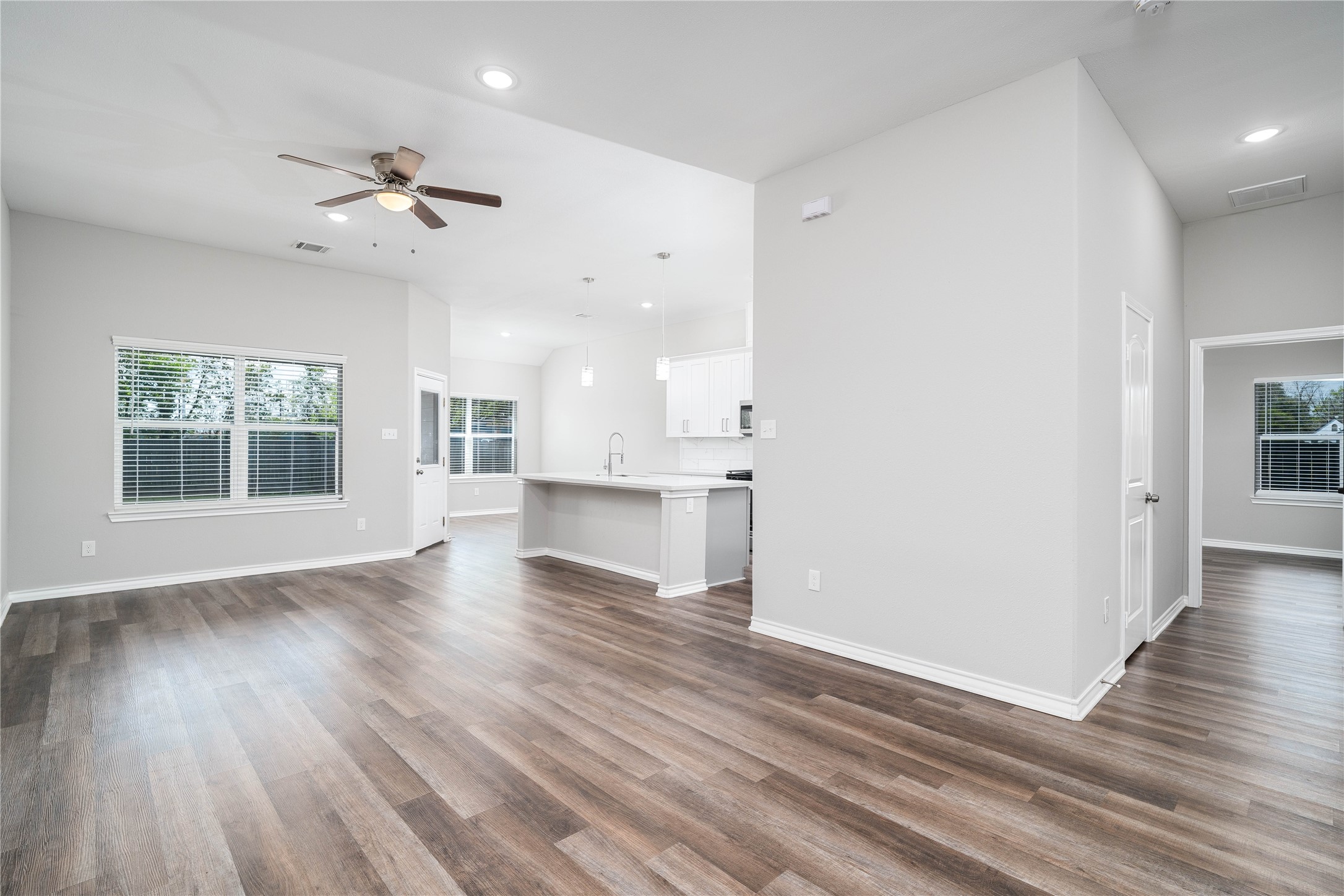 231 McCormick Street Columbus, TX 78934 - Photo 8 of 27 Living Room – Open-concept living area with high ceilings, recessed lighting, and seamless connection to the kitchen and dining spaces.