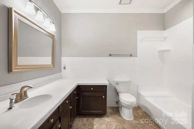 a bathroom with a toilet a sink and mirror