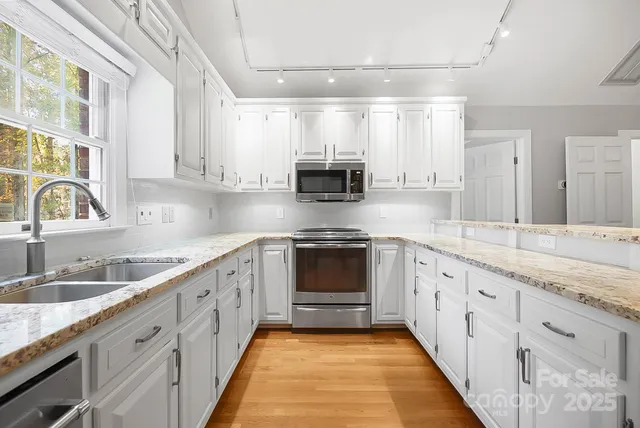 a kitchen with granite countertop a sink stove and cabinets