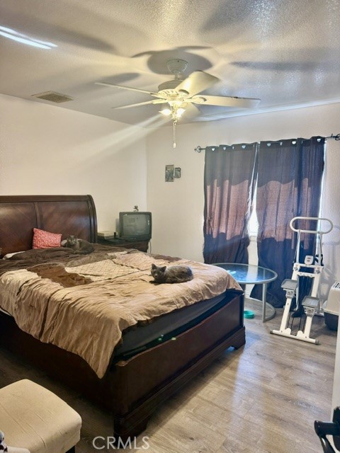 13375 Rincon Road Apple Valley, CA 92308 - Photo 26 of 72 a bedroom with a bed and wooden floor