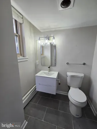 a bathroom with a toilet a sink and mirror