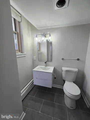a bathroom with a toilet a sink and mirror