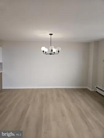 a view of an empty room with chandelier fan