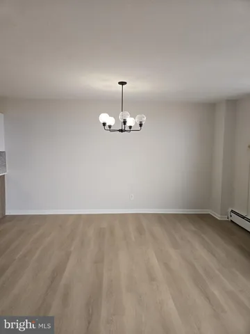a view of an empty room with chandelier fan