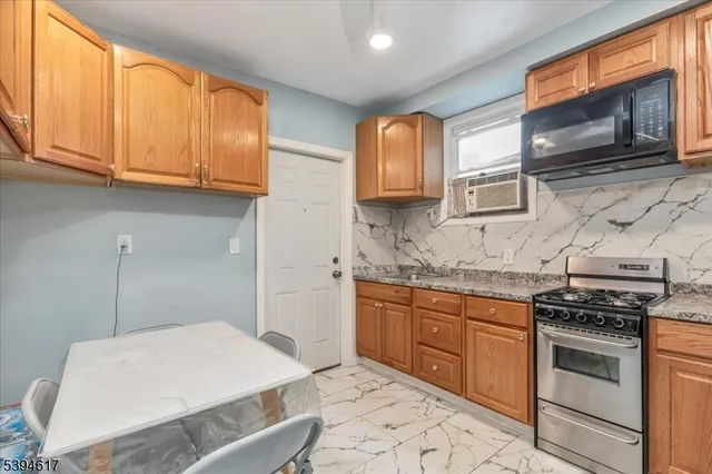 a kitchen with stainless steel appliances granite countertop a sink stove and microwave