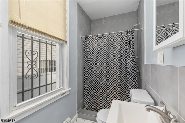 a white toilet sitting next to a window