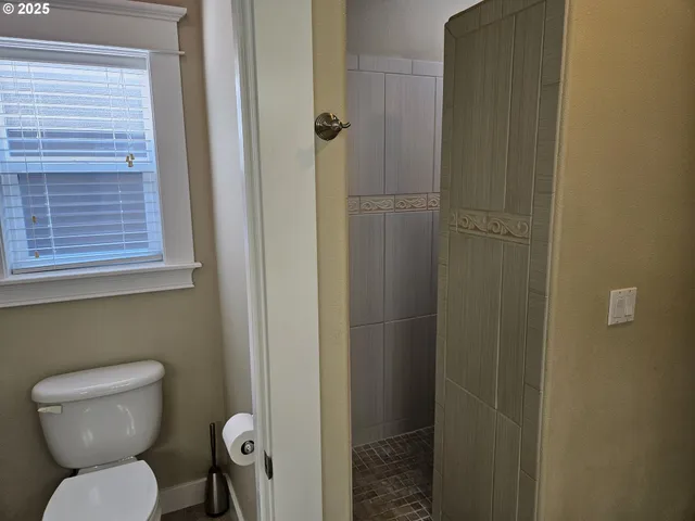 a bathroom with a toilet and a shower