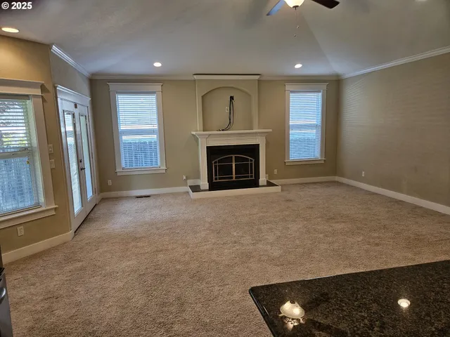a view of an empty room with a fireplace and a window