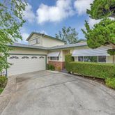a view of a house with a yard and potted plants
